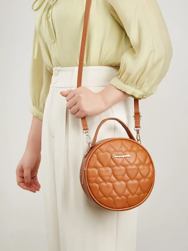 Petit sac rond en cuir marron porté par une femme