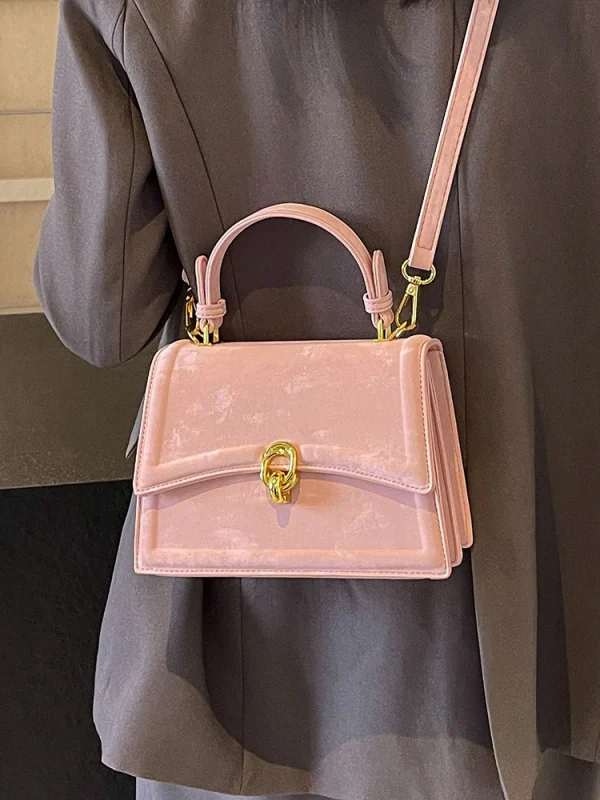 sac à main rose en velours avec boucle dorée